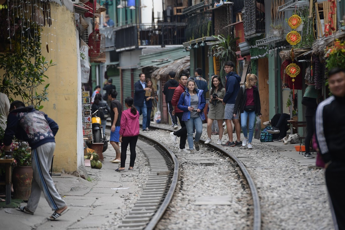 Dọc đoạn đường tàu tại đây vẫn nhộn nhịp cảnh tượng khách du lịch đi lại, chụp ảnh trên đường ray, ngồi uống cà phê bên đường tàu để… đợi tàu chạy qua. (Ảnh: Trọng Tùng)