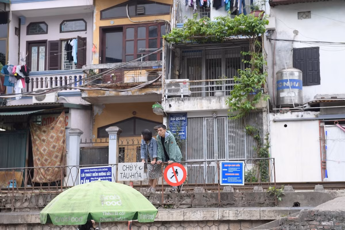 Thậm chí, các bạn trẻ đứng ngay sát biển cảnh báo trên đường ray tàu, ngay trước mặt lực lượng dân phòng nhưng cũng không bị nhắc nhở. (Ảnh: Trọng Tùng)