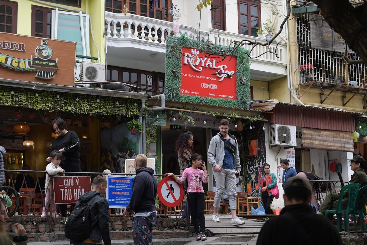 Ngoài ra, khi đi qua tụ điểm cà phê, tàu thường phải chạy chậm hơn 30 km/h và lái tàu phải chờ du khách nhường đường, gây chậm tàu, nhiều đoàn tàu thay đổi giờ chạy nên có thể đi qua bất ngờ và không đảm bảo an toàn cho du khách đi lại khu vực trên. (Ảnh: Trọng Tùng)