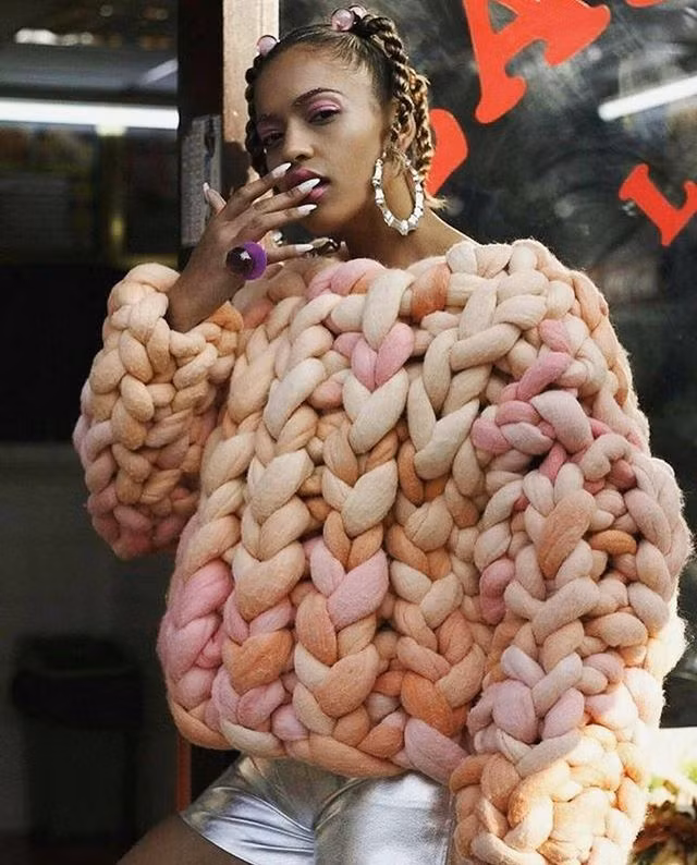 Được cấu tạo từ những sợi len khổng lồ, chiếc áo trở nên vô cùng ấm áp. Vậy nhưng, cô nàng mặc cùng hotpants trong kiểu thời tiết nắng chói chang phía sau khiến người nhìn phát ngốt.