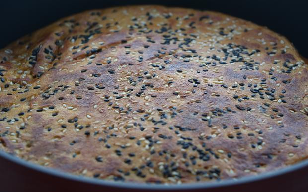 7. Cuối cùng đổ phần bột bí đỏ còn lại, dàn đều. Rắc hạt vừng, đậy nắp vung lại để 5 phút, sao cho rán vàng 2 mặt.