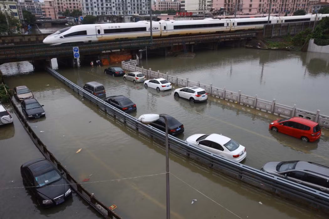 Loạt ô tô chật vật băng qua đoạn đường ngập nước.