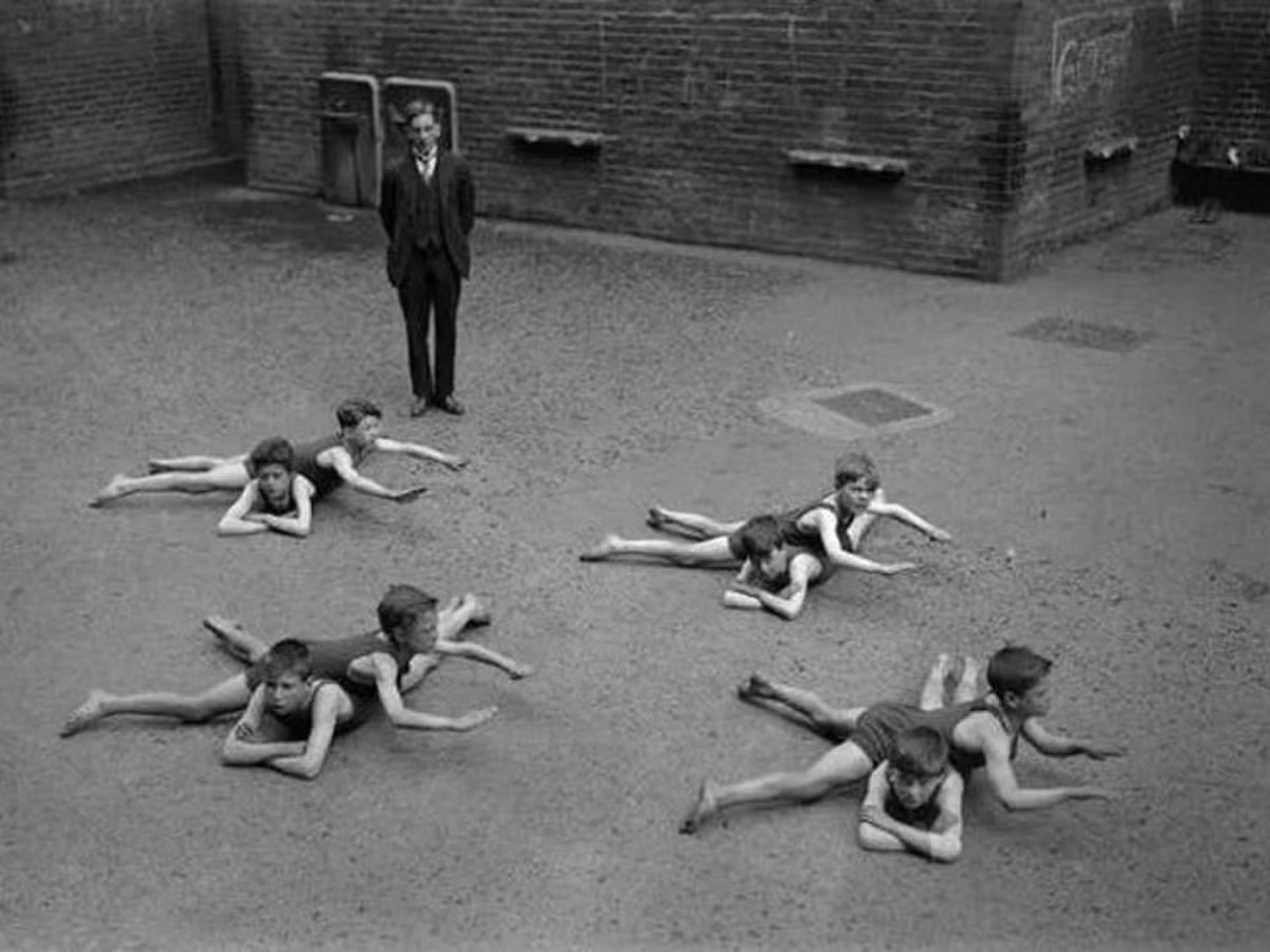 Các học sinh tại một trường học ở Anh học các động tác bơi cơ bản trên nền đất thay vì bể bơi. Bức ảnh hiếm có này được chụp vào những năm 1920.
