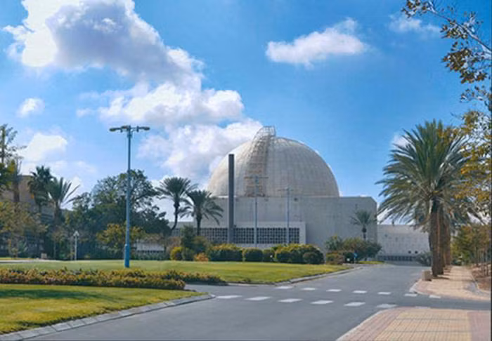 Israel tuyên bố rằng lò phản ứng hạt nhân và cơ sở nghiên cứu này nhằm mục đích nghiên cứu khoa học nguyên tử. Tuy nhiên, mục đích của lò phản ứng được cho là sản xuất vật liệu hạt nhân có thể được sử dụng trong vũ khí hạt nhân của Israel.