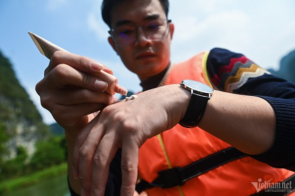 Nam du khách đến từ Hà Nội thoa kem chống nắng trong thời gian ngồi thuyền tham quan cảnh sắc Tràng An. "Tôi và bạn chủ đích mang kem chống nắng vì biết hôm nay nhiệt cao. Trước khi xuống thuyền chúng tôi còn để lại áo khoác ở xe, chỉ mặc trang phục thoáng mát", anh nói. 