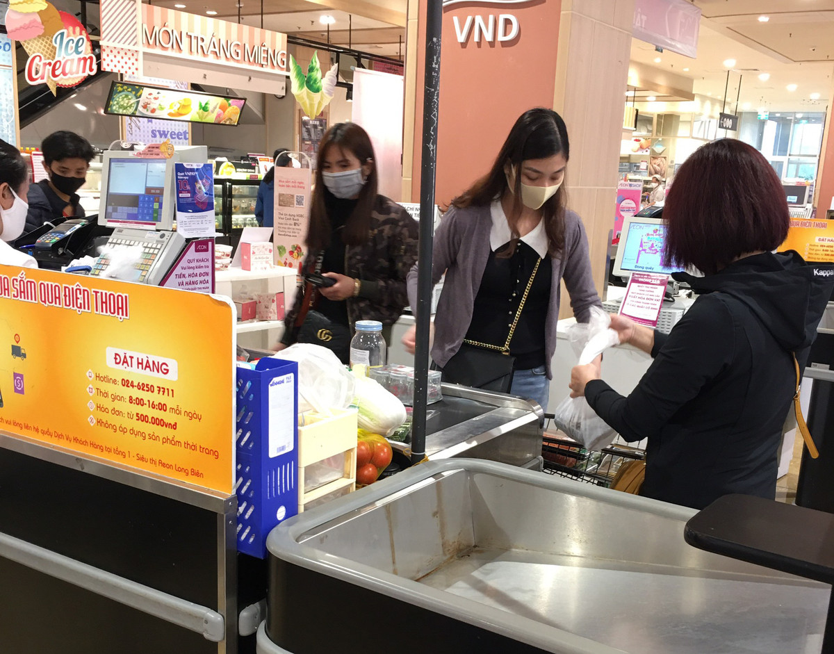 Những khách hàng chờ thanh toán với những chiếc khẩu trang kín mít trên khuôn mặt.