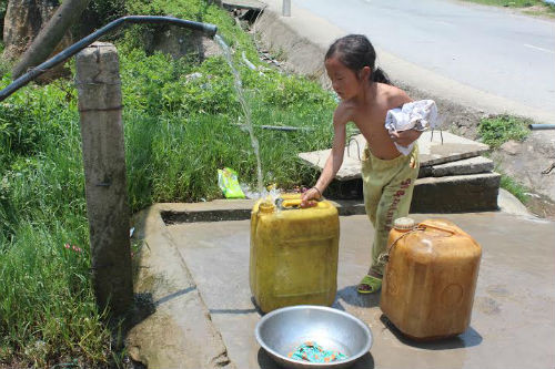 Một bé gái người dân tộc tranh thủ đi tắm và lấy nước ở vùng miền núi huyện Kỳ Sơn.