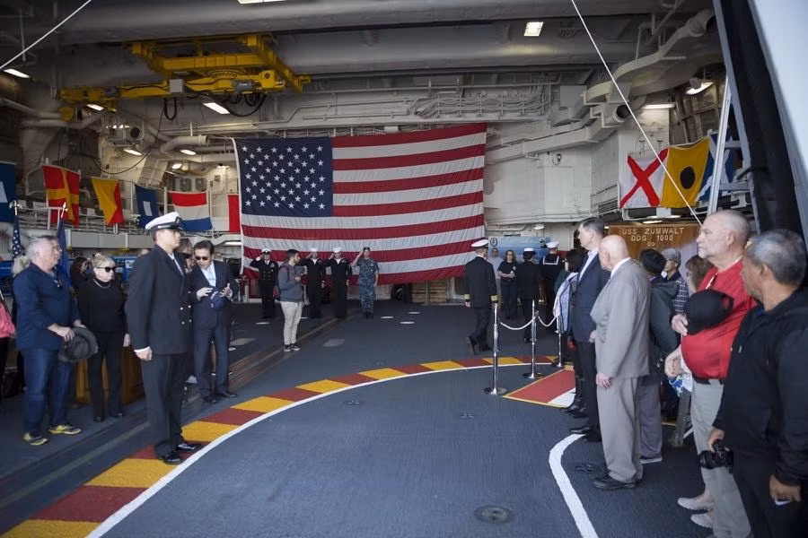 Các vị quan chức phát biểu và làm nghi lễ biên chế ngay trong hangar siêu hạm DDG-1000. Nguồn ảnh: QQ