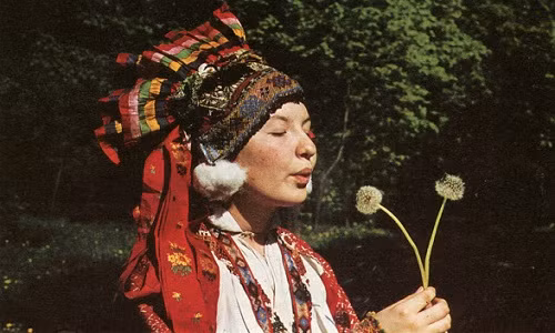 Hình ảnh một phụ nữ Liên Xô tuyệt đẹp trong khoảnh khắc thổi những cánh hoa bông hoa bồ công anh đang cầm trên tay.