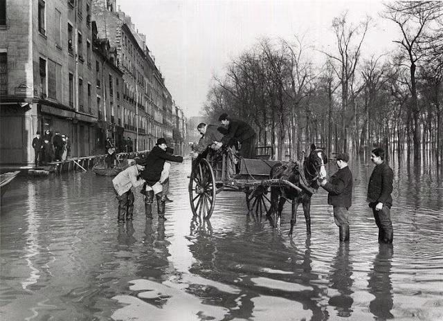 Nước ngập gần đến đầu gối. Người nào đi ra đường cũng đều đi những đôi ủng.