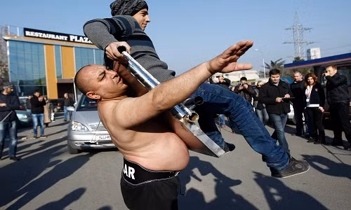 Không chỉ có khả năng hút thìa, Elchiyev còn khiến mọi người kinh ngạc khi có thể dùng bụng hút một tấm nắp capo xe đang có một người trẻ tuổi ngồi trên.