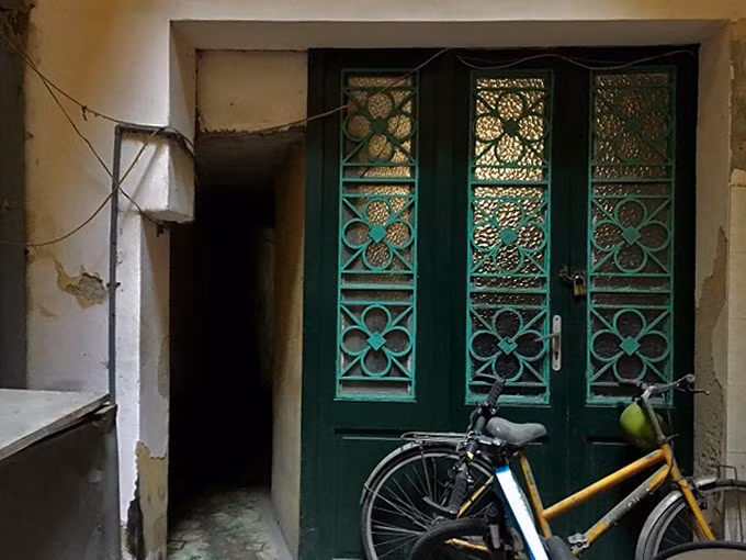 Cửa gỗ màu xanh lá, tường quét vôi vàng là màu đặc trưng của kiến trúc thời Pháp thuộc ở khu phố cổ. Ảnh: Thanh Hải