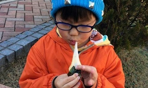 Một cậu bé ăn bánh gạo nếp mochi. Ảnh: AP Photo/Tetsuya Sarut.