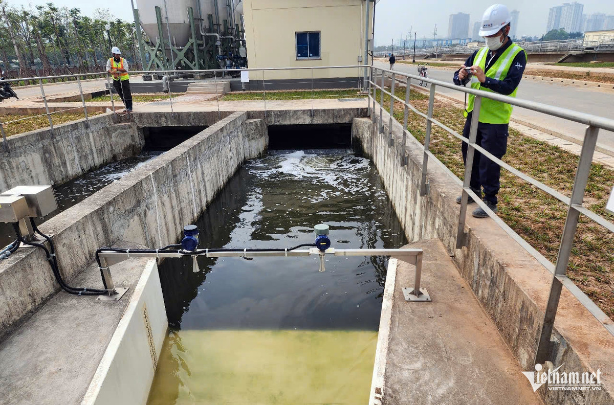 Cán bộ kỹ thuật của Nhà máy xử lý nước thải Yên Xá kiểm tra chất lượng nước đã được 'hồi sinh' trước khi xả ra sông Tô Lịch.