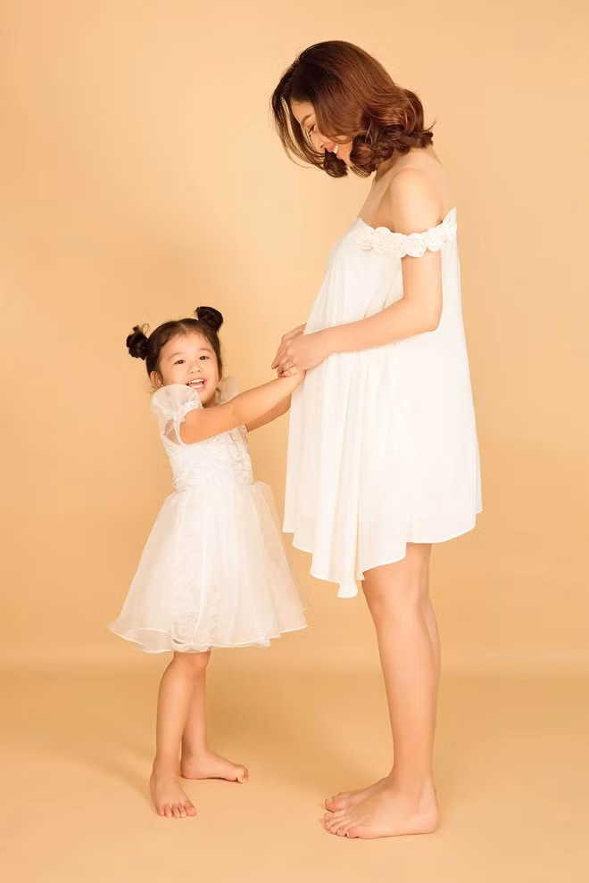 Hai mẹ con người đẹp sinh năm 1985 diện đầm trắng ton sur ton cùng chụp ảnh.