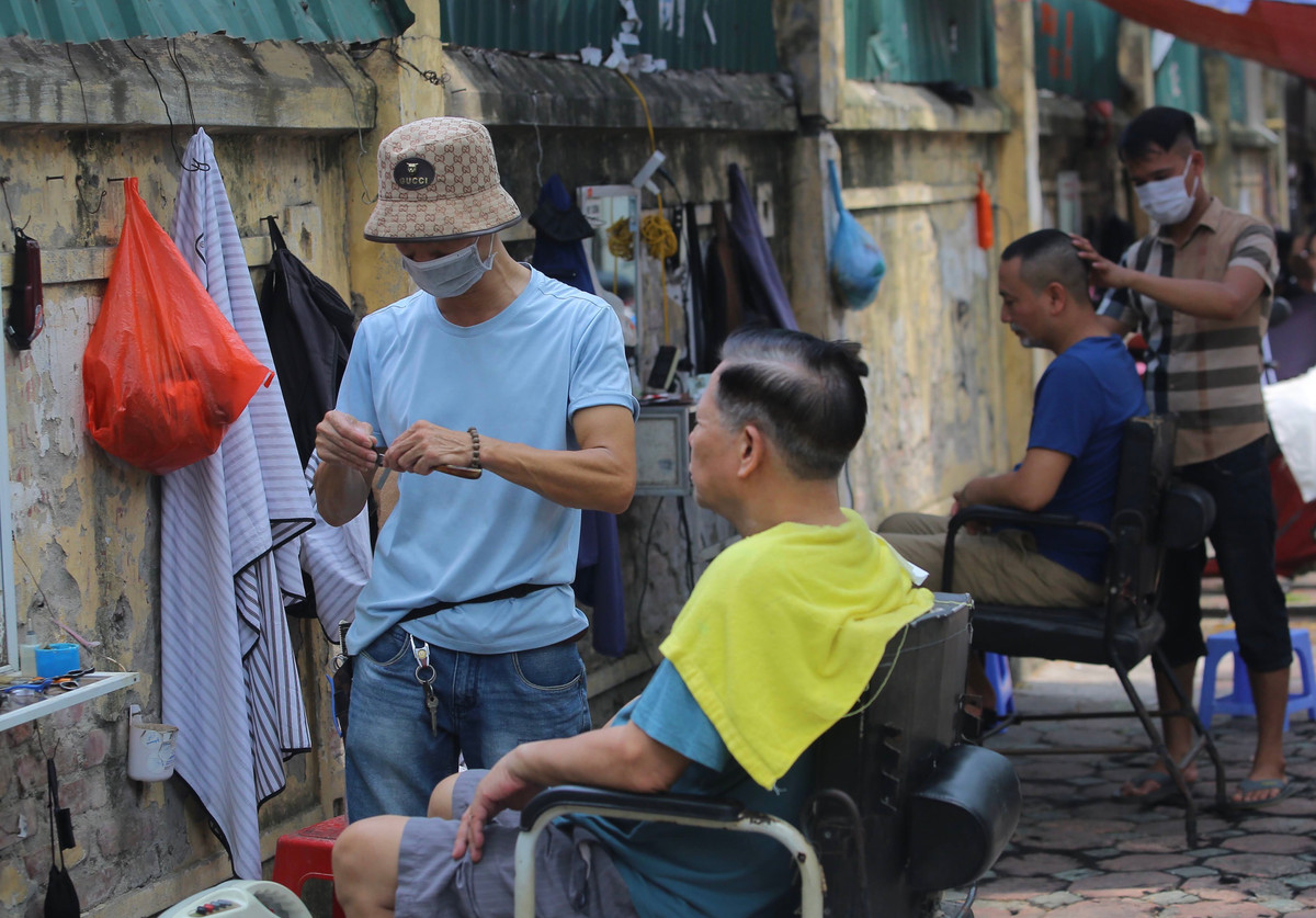 Anh Tuấn, chủ cửa hàng cắt tóc tại đây cho biết khách đã ngồi chờ từ 8h sáng vì ai cũng muốn cắt thời điểm đó cho đỡ nóng.