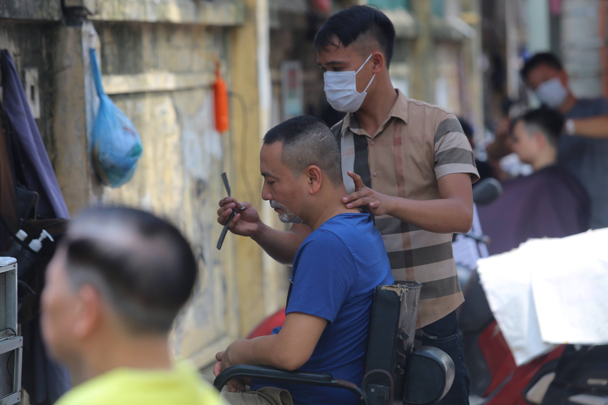 Trên đường Thái Thịnh (quận Đống Đa), nhiều hàng cắt tóc ngoài trời mở ra gần nhau nhưng rất đông khách.