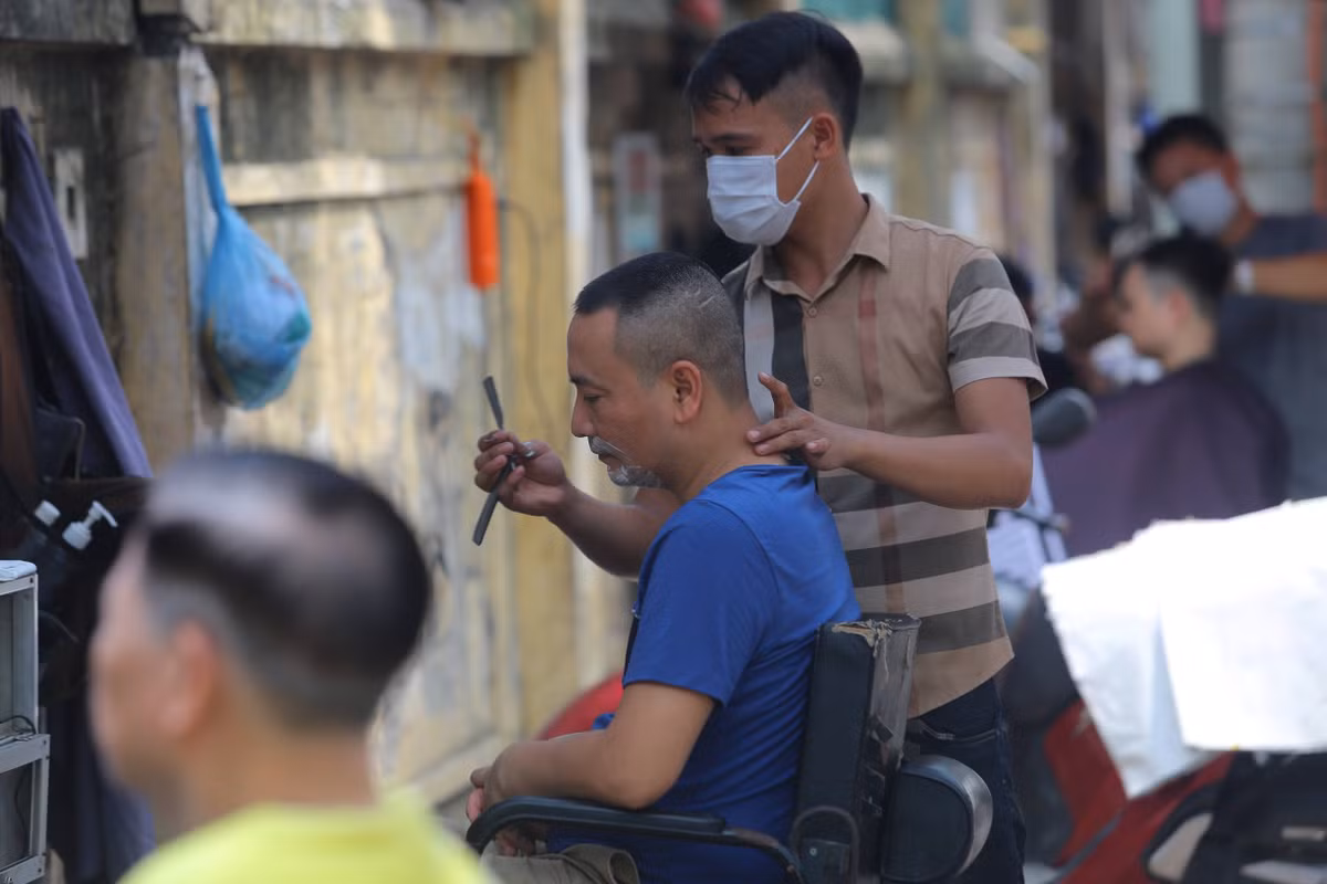 Trên đường Thái Thịnh (quận Đống Đa), nhiều hàng cắt tóc ngoài trời mở ra gần nhau nhưng rất đông khách.
