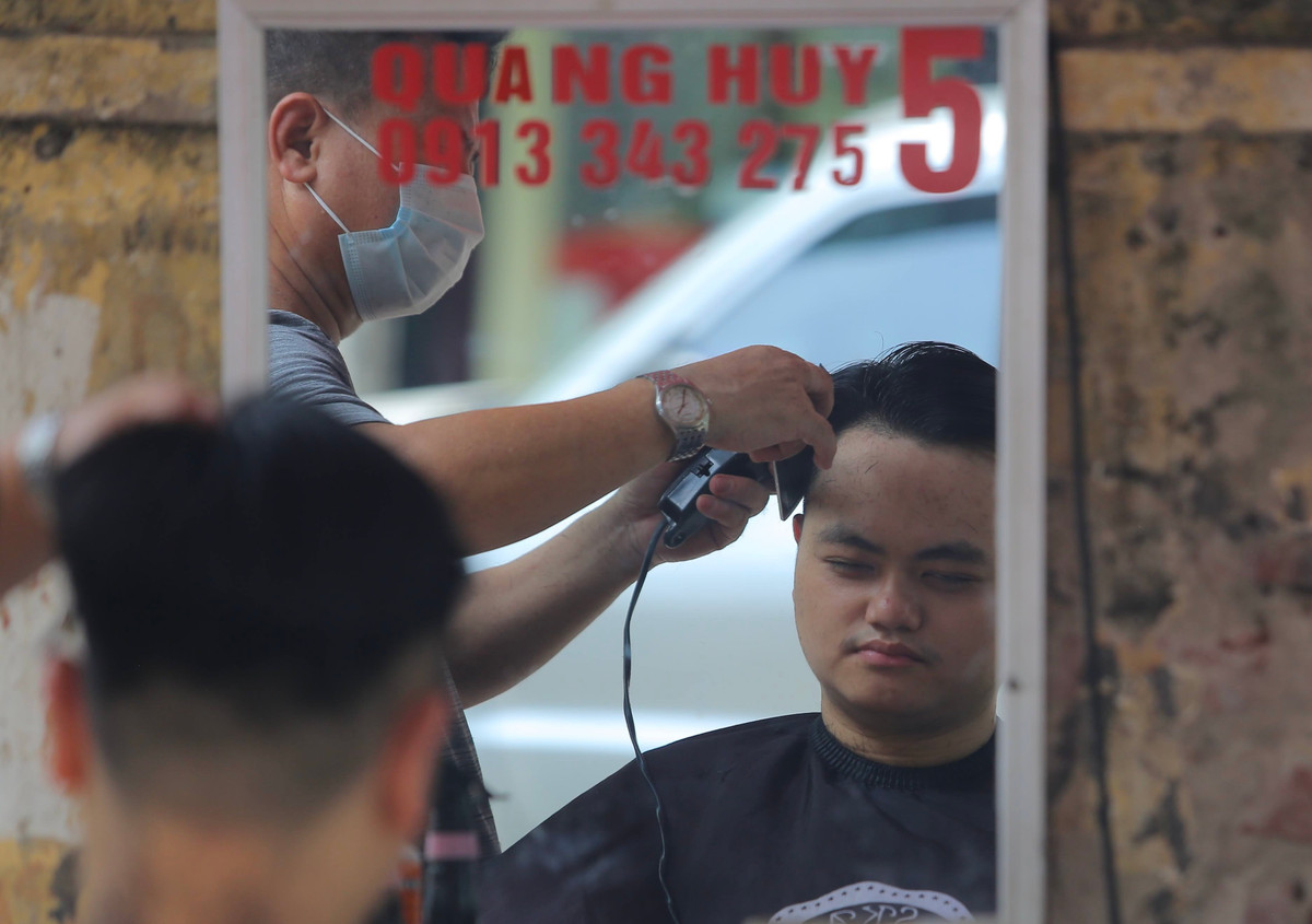 Mặc dù chiều nay nhiệt độ ngoài trời vẫn oi bức nhưng đã giảm nhiều so với 2 ngày vừa qua. Chính vì vậy, các cửa hàng cắt tóc ngoài trời là giải pháp an toàn và hiệu quả trong mùa dịch COVID-19.