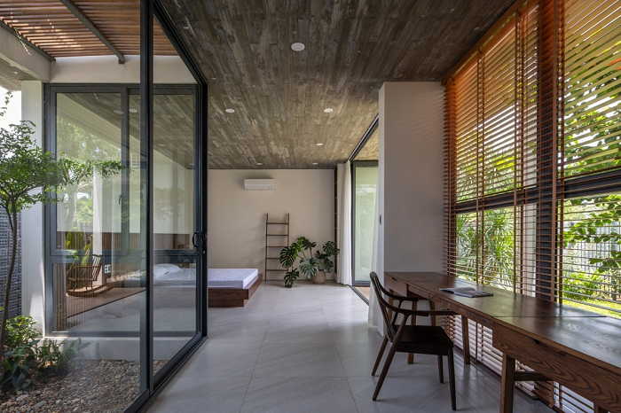 Các phòng ngủ được bố trí hướng ra các mảng xanh. Phòng được ngăn cách với bên ngoài bằng cửa kính trượt và rèm vải để chủ nhà tận hưởng bầu không khí tự nhiên và đóng lại khi cần sự riêng tư.