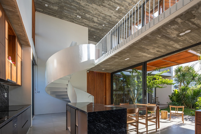 Khu vực bếp và phòng ăn rộng rãi, có cầu thang xoắn ốc màu trắng tạo điểm nhấn.