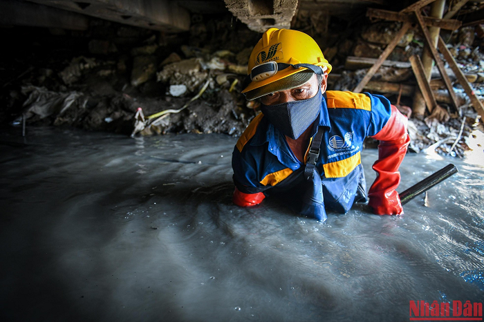 Rác "lặn sâu" dưới đáy bùn đục ngầu khiến ông Công phải cố hết sức để có thể khơi thông dòng chảy. Làm việc trong môi trường thế này, việc "nếm thử" nước cống, hít mùi cống... là việc khó tránh...