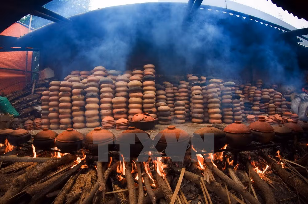 Cá được kho theo phương thức cổ truyền: kho bằng niêu đất trên bếp củi suốt 10 tiếng đồng hồ để cá mềm và thấm, có thể ăn được cả xương. (Ảnh: Trọng Đạt/TTXVN)