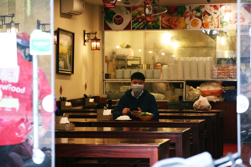 Để đảm bảo an toàn cho sức khỏe trước diễn biến phức tạp của dịch bệnh COVID-19 nên khách hàng đến quán bún chả nằm trên đường Trần Thái Tông (Cầu Giấy, Hà Nội) đều tuân thủ việc đeo khẩu trang và sát khuẩn tay trước khi ngồi vào bàn ăn..