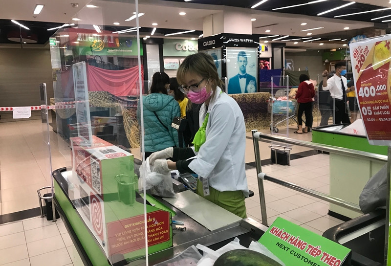 Để bảo vệ an toàn cho bản thân và khách hàng siêu thị Big C Thăng Long đã dựng vách ngăn ở quầy thanh toán, đồng thời dán vạch khoảng cách để khách xếp hàng chờ thanh toán.