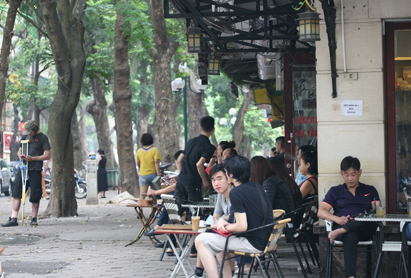 Trái ngược với các nhà hàng, quán ăn thì hầu hết các quán cà phê trên phố Hà Nội đều rất đông khách vào trưa ngày 30/4. (Ảnh chụp trên phố Phan Đình Phùng).