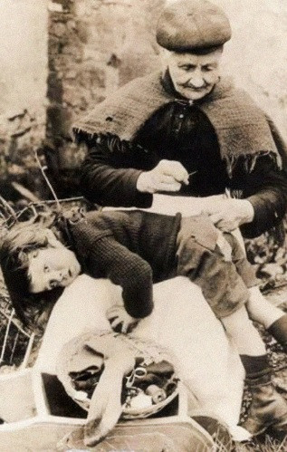 Hình ảnh ấm áp người bà vá chiếc quần bị rách cho cháu. Ảnh chụp năm 1907.