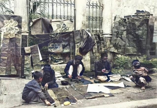 Các thầy đồ ngồi viết thư pháp. Nhiều người dân ở Hà Nội mua những bức thư pháp này để treo trong nhà.