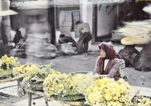 Người phụ nữ bày bán hoa cúc trong một phiên chợ ở Hà Nội.