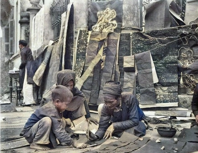 Thầy đồ tỉ mỉ ngồi viết thư pháp trên một con phố ở Hà Nội.