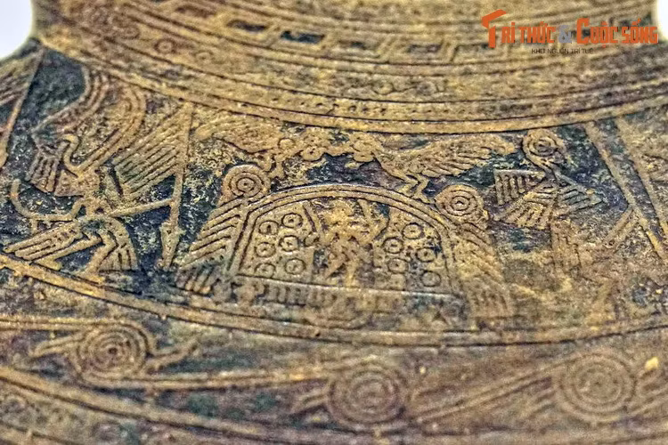 Họa tiết trên trống đồng Hoàng Hạ thể hiện đôi chim đuôi dài đậu trên nóc nhà sàn cầu mùa mái vòm. Dường như chúng đang mớm thức ăn cho nhau.