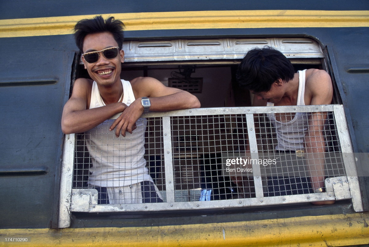 Hai nam giới bên cửa sổ toa tàu thuộc đoàn tàu Thống Nhất.