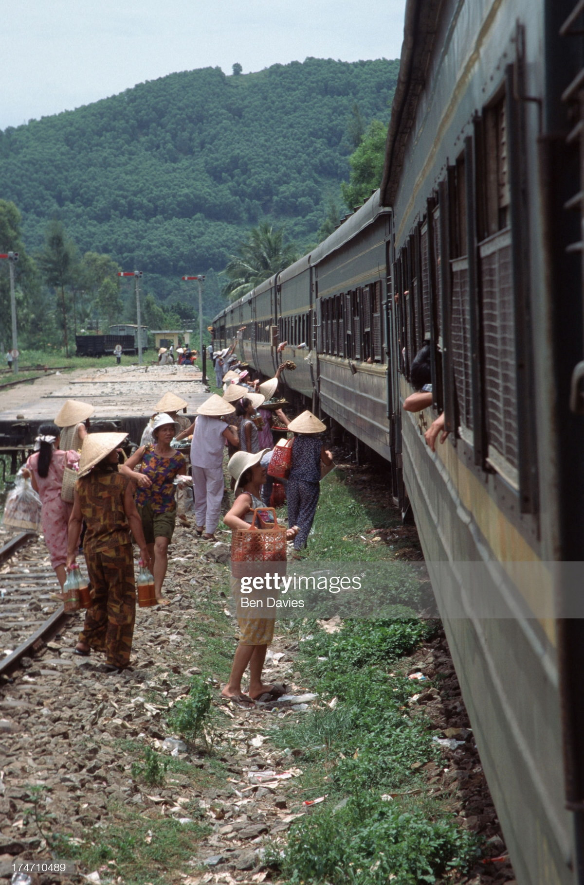 Những người bán hàng rong mời chào du khách trên đoàn tàu Thống Nhất tại một sân ga ở miền Trung.