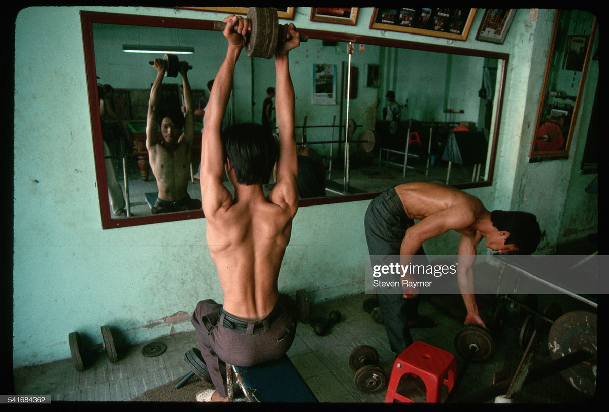 Các nam giới đẩy tạ trong một câu lạc bộ thể hình, 1994.