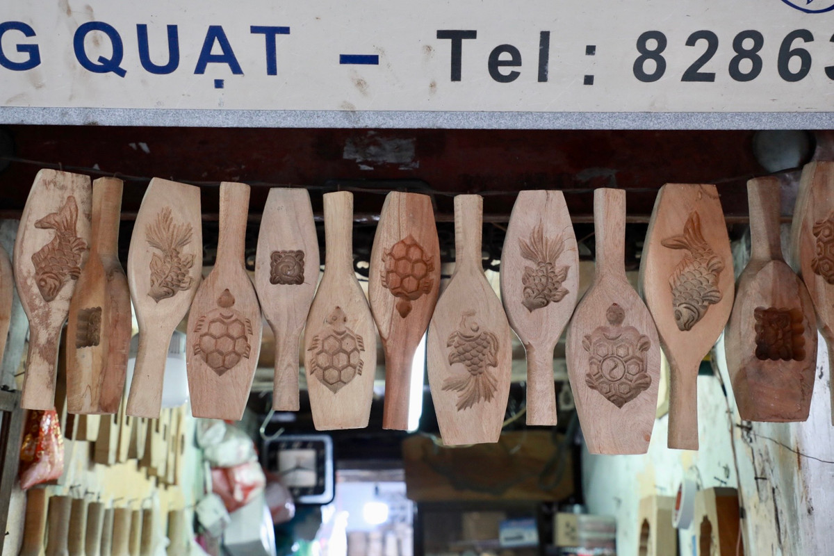 Những phôi gỗ chạm khắc đa dạng mẫu mã được treo trước cửa tiệm.