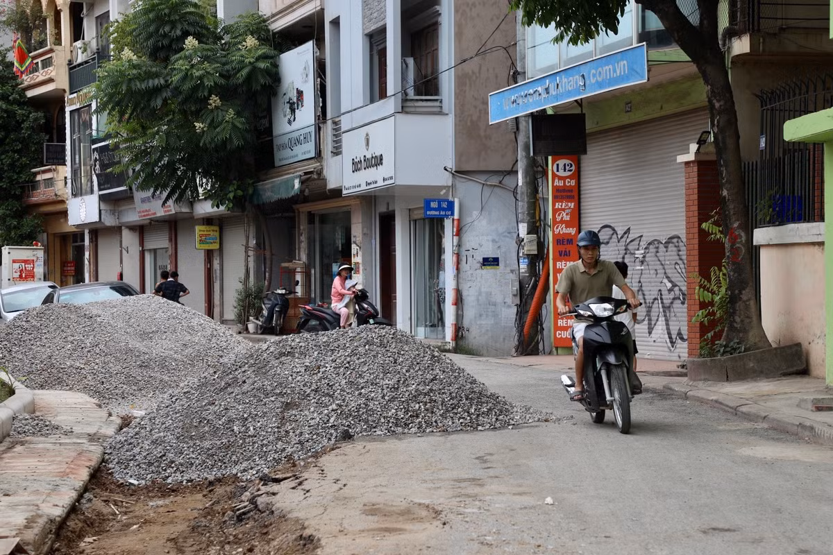 Vật liệu xây dựng, đất đá còn chất đống, ngổn ngang dọc hai bên đường.