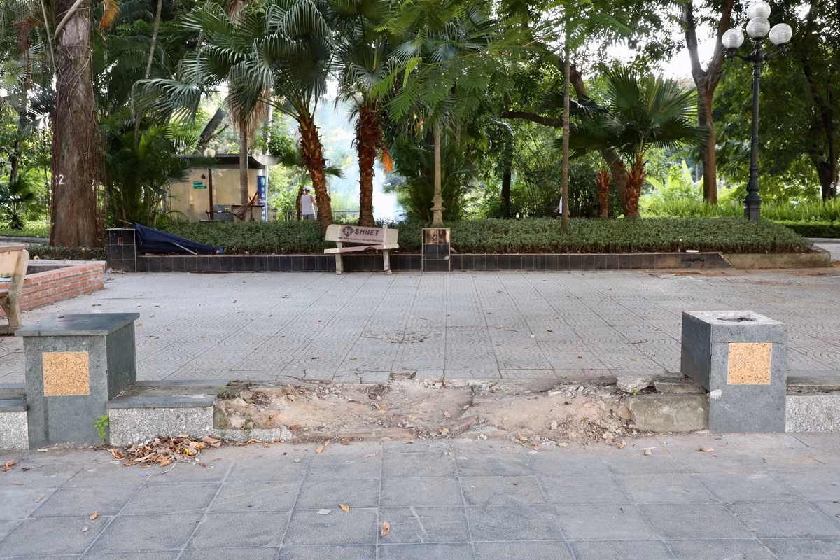 Một khu vực tường bao hư hỏng trở thành lối đi tự phát của xe máy, xe đạp vào vườn hoa.