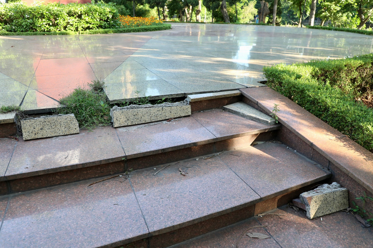 Bậc thang lên xuống khu vực tượng đài nứt vỡ.