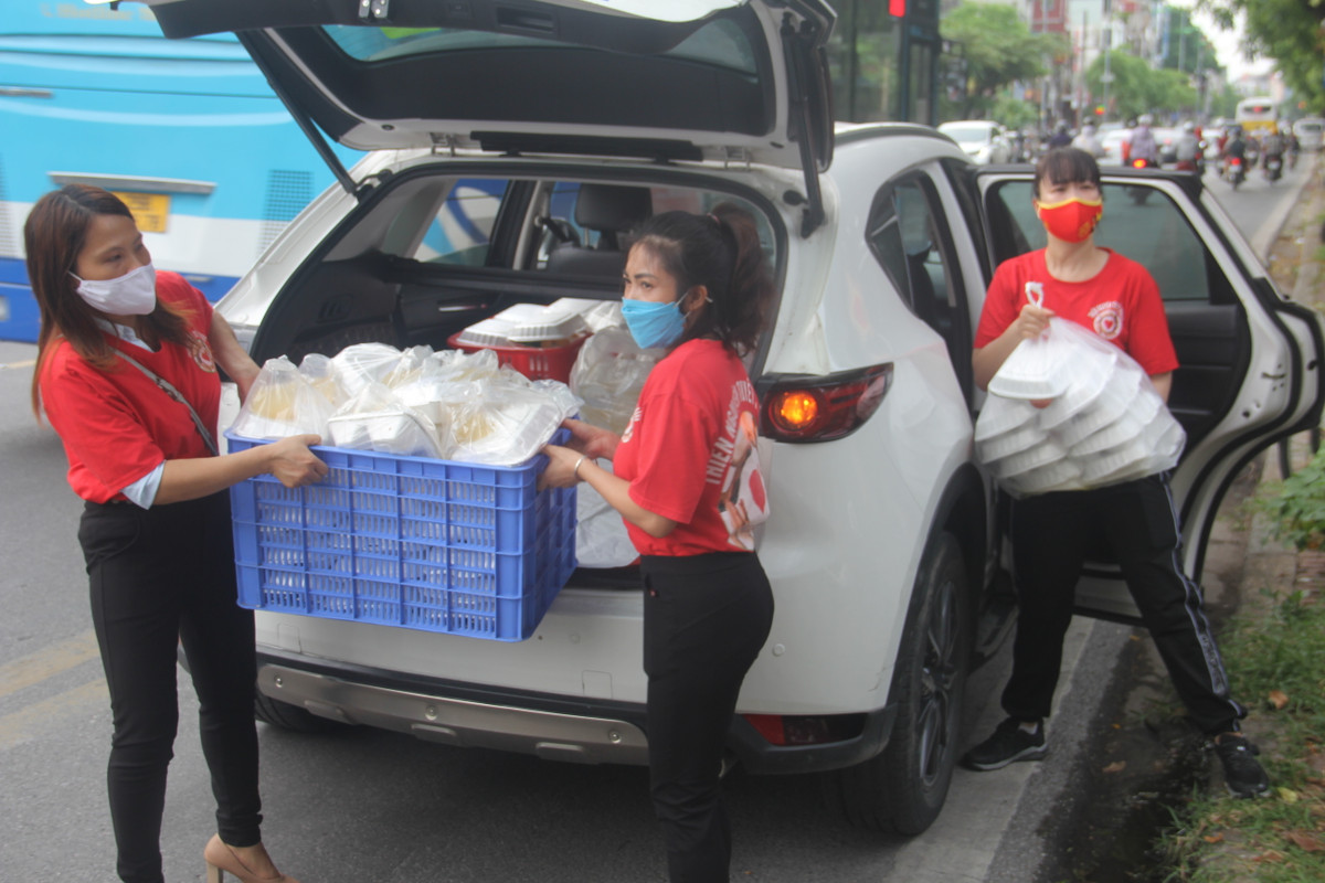 Tình nguyện viên mang theo những suất cơm đến các địa điểm để chuẩn bị phát cho người khó khăn.