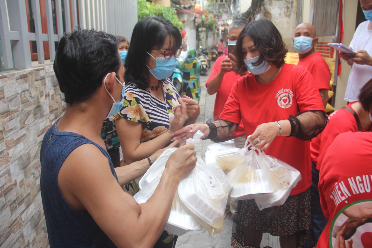 Bà Cao Thị Ánh Tuyết (người sáng lập CLB thiện nguyện Tuyết Phong) cho biết: "Dịch COVID-19, ảnh hưởng đến bất cứ ai, đặc biệt là những người bệnh nặng, hiểm nghèo, người vô gia cư, người lao động nghèo... vì vậy, CLB tập trung hỗ trợ, giúp đỡ suất cơm miễn phí cho những người này." (Bà Tuyết người mặc áo đỏ phát cơm)