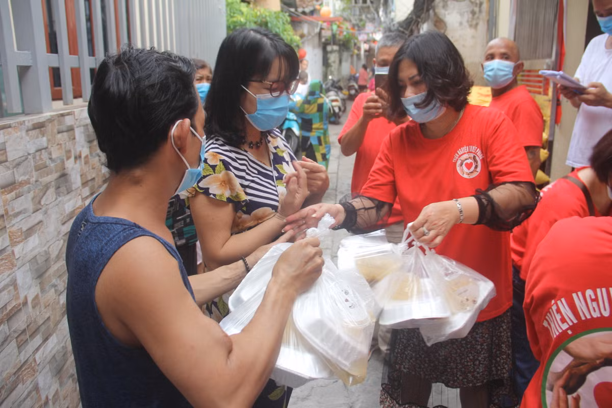 Bà Cao Thị Ánh Tuyết (người sáng lập CLB thiện nguyện Tuyết Phong) cho biết: "Dịch COVID-19, ảnh hưởng đến bất cứ ai, đặc biệt là những người bệnh nặng, hiểm nghèo, người vô gia cư, người lao động nghèo... vì vậy, CLB tập trung hỗ trợ, giúp đỡ suất cơm miễn phí cho những người này." (Bà Tuyết người mặc áo đỏ phát cơm)