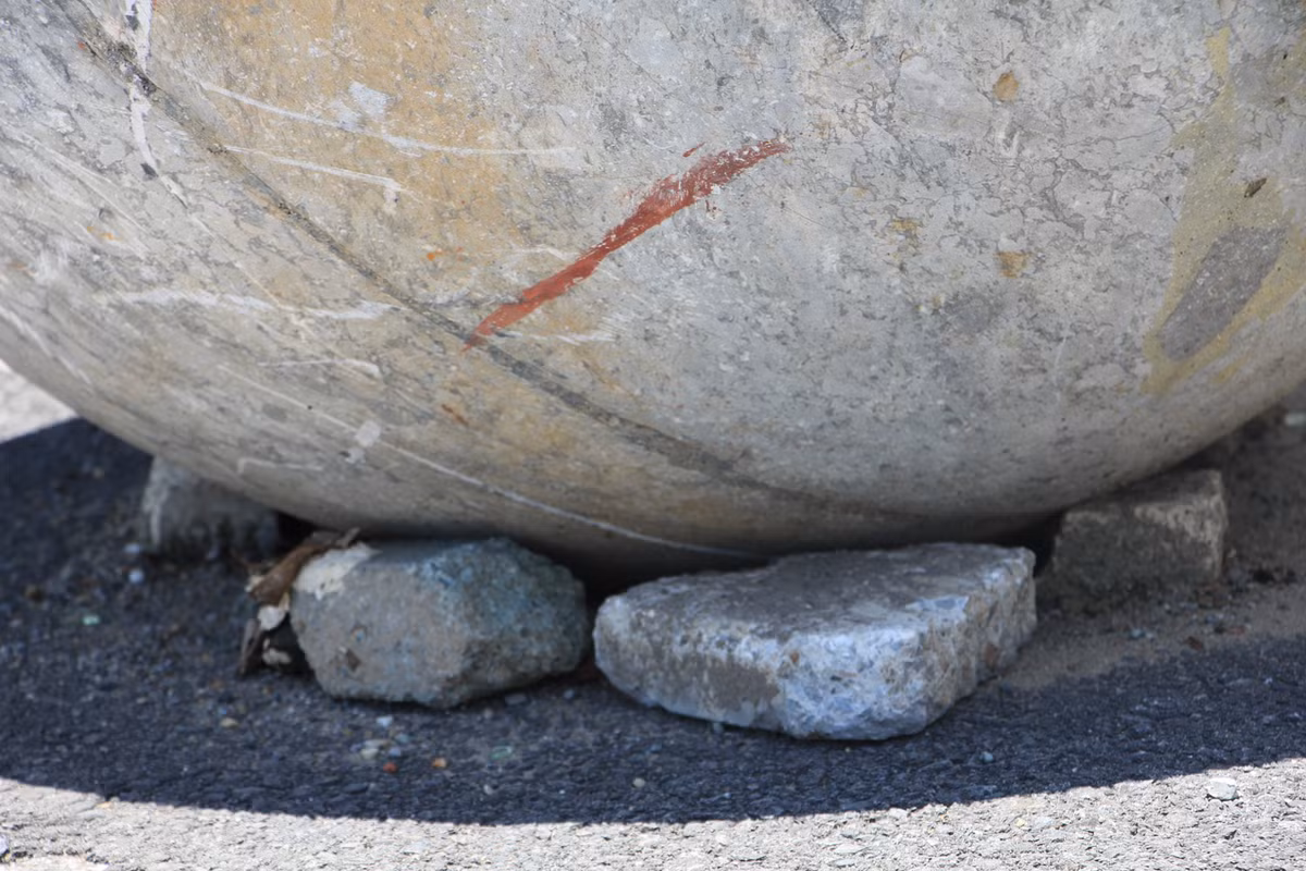 Những viên gạch kê tạm bợ báo hiệu số phận hẩm hiu của những quả cầu đá này.