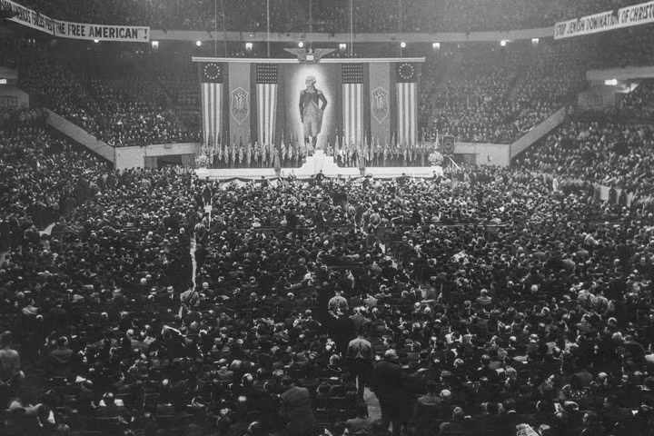 Chúng treo chân dung cố Tổng thống Mỹ George Washington, coi đó là “nhà phát xít đầu tiên”. Ảnh chụp vào tháng 2/1939. Trong ảnh có khẩu hiệu “Ngăn chặn Do Thái thống trị người Mỹ Kitô giáo”.