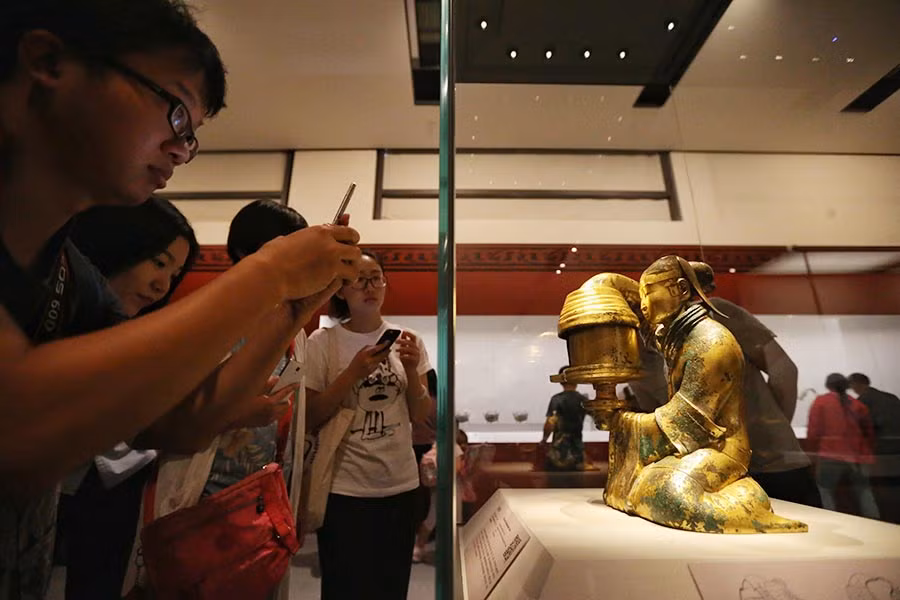 Khách tham quan tới xem buổi triển lãm thích thú khi chiêm ngưỡng hiện vật giá trị và chụp ảnh các cổ vật.