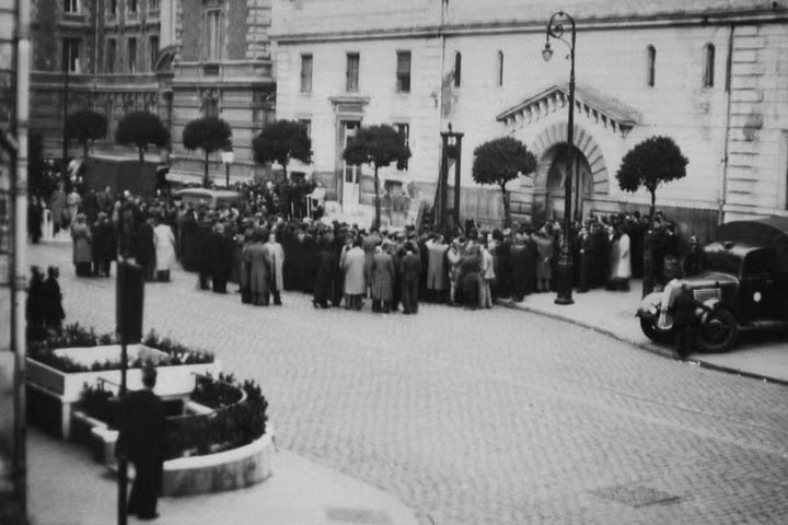Đám đông tụ tập quanh máy chém lúc buổi hành quyết diễn ra bên ngoài nhà tù Saint-Pierre vào sáng sớm ngày 17/6/1939.