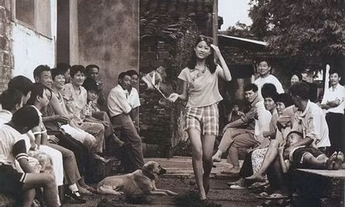 Một cô gái với phong cách ăn mặc sành điệu ở Trung Quốc thập niên 80 được nhiều hàng xóm chú ý.